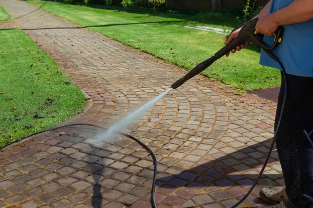 A Man cleaning street by pressure washing