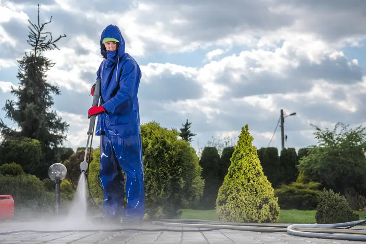 A man pressure washing sidewalk in california