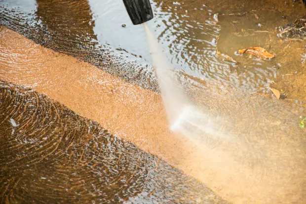 Cleaning dirty backyard tiles by pressure washing