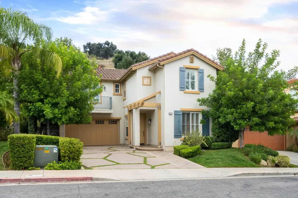 Pressure washed house with a garage and front yard tress in california