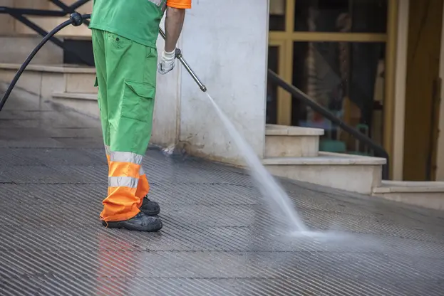 A cleaner cleaning dirty floor by pressure washing