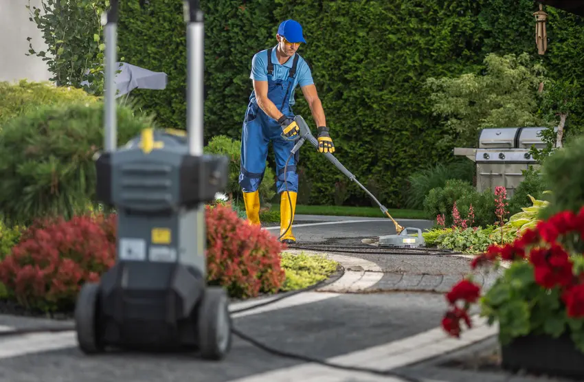 A cleaner washing garden pathways in a residenatial outdoor