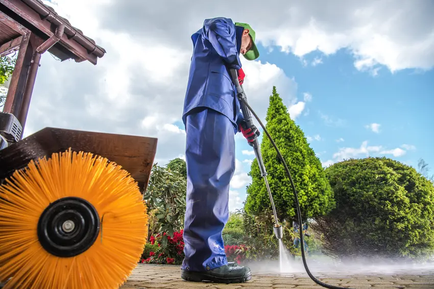 a man pressure washing residential concrete paths