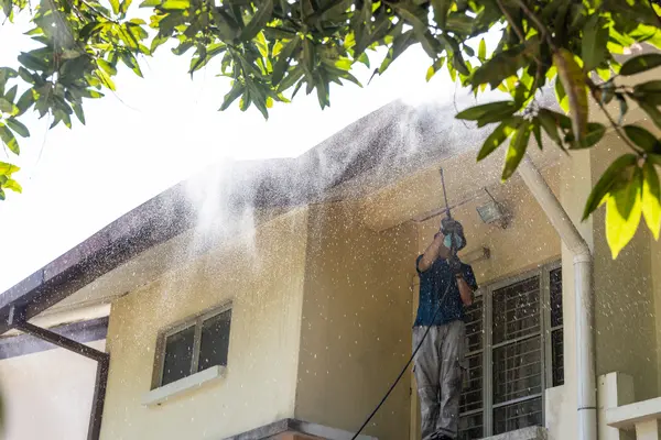 cleaner using pressure washing to clean house roof ceiling