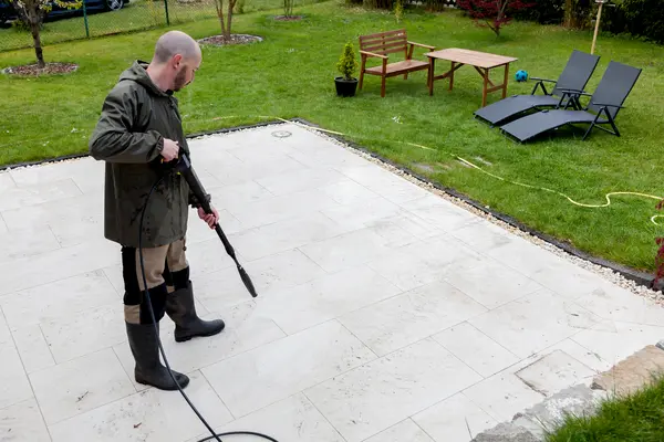 A worker cleaning patio floor