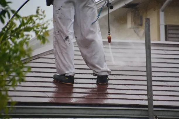 Js pristine worker cleaning roof tiles